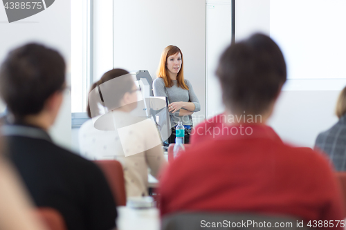 Image of Woman giving presentation in lecture hall at university.