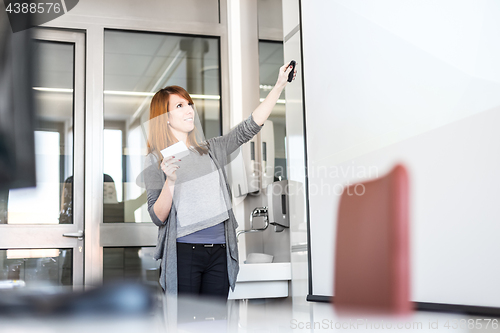 Image of Woman giving presentation in lecture hall at university.