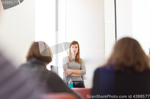 Image of Woman giving presentation in lecture hall at university.