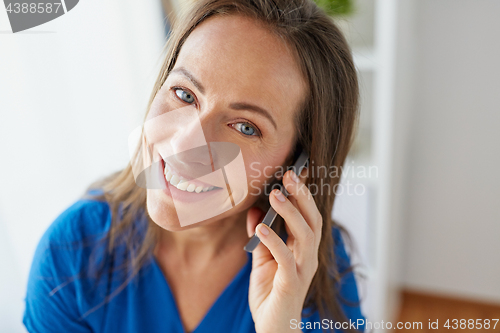 Image of woman calling on smartphone at office or home