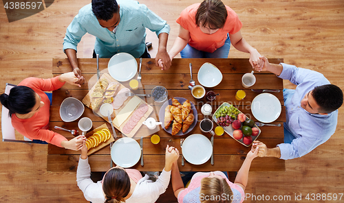 Image of group of people at table praying before meal