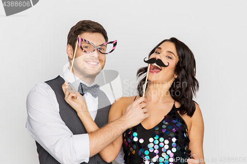 Image of happy couple with party props having fun