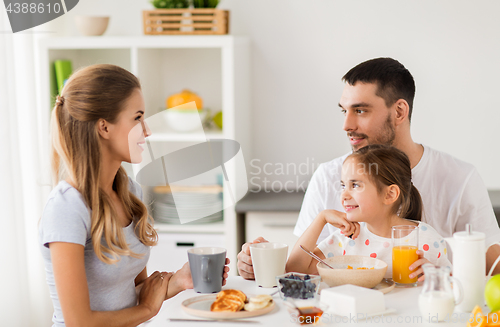 Image of happy family having breakfast at home