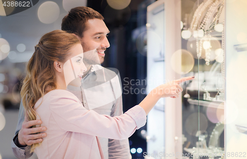 Image of couple looking to shopping window at jewelry store