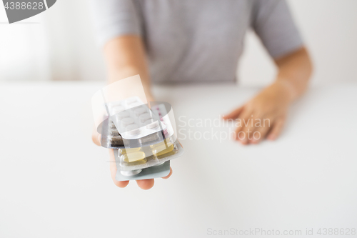 Image of woman hands holding packs of pills