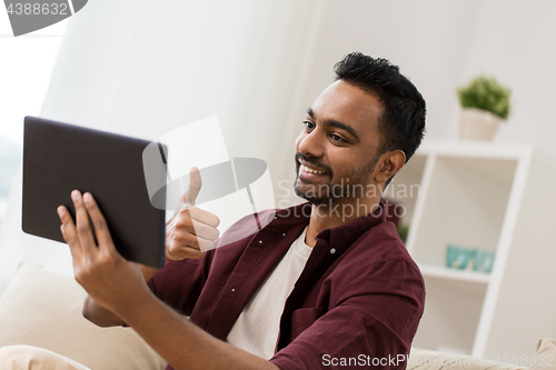 Image of happy man with tablet pc having video chat at home