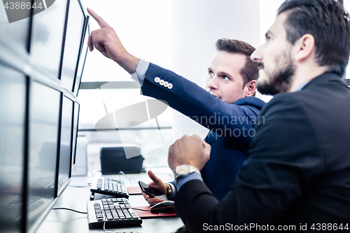 Image of Stock traders looking at market data on computer screens.