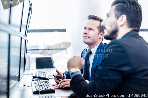 Image of Stock traders looking at market data on computer screens.