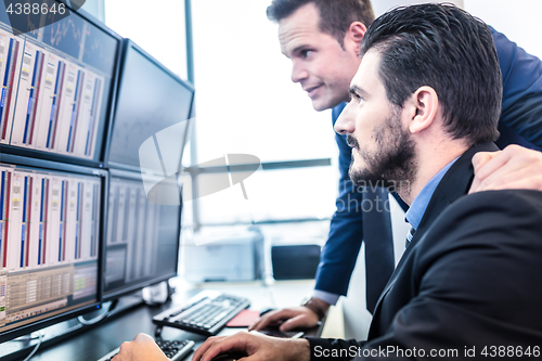 Image of Stock traders looking at computer screens.