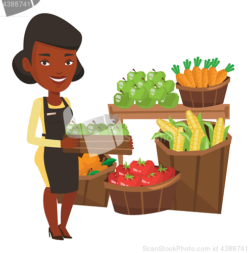 Image of Supermarket worker with box full of apples.