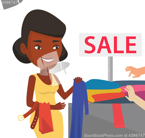 Image of Young woman choosing clothes in shop on sale.