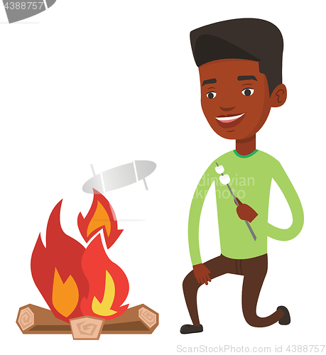 Image of Man roasting marshmallow over campfire.