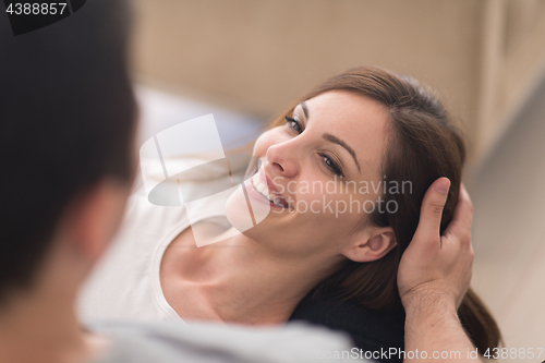 Image of young handsome couple hugging on the sofa