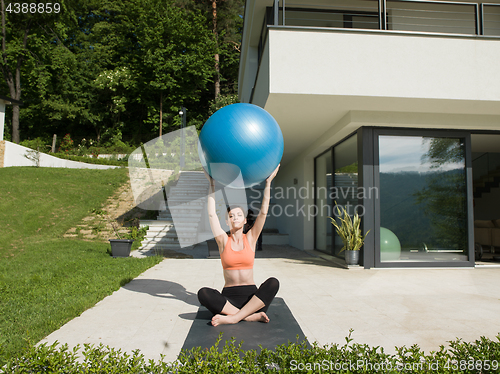 Image of woman doing exercise with pilates ball