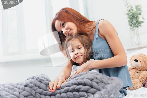 Image of A little cute girl enjoying, playing and creating with toy with mother