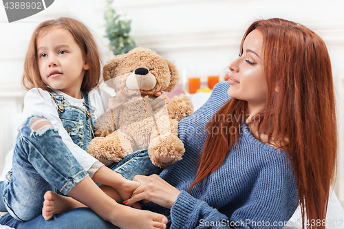 Image of A little cute girl enjoying, playing and creating with toy with mother