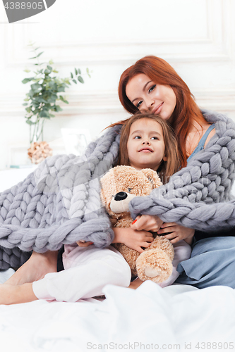 Image of A little cute girl enjoying, playing and creating with toy with mother