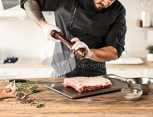 Image of Man cooking meat steak on kitchen