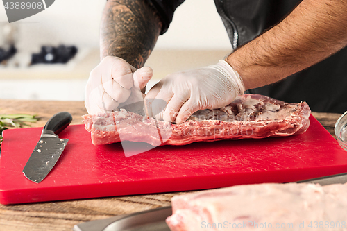 Image of Man cooking meat steak on kitchen