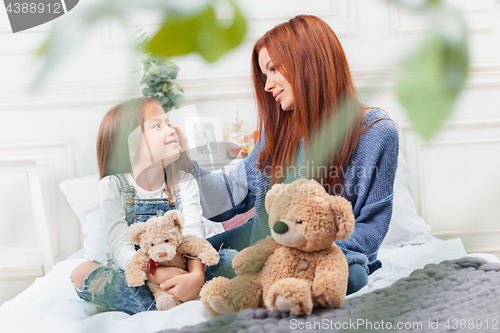 Image of A little cute girl enjoying, playing and creating with toy with mother