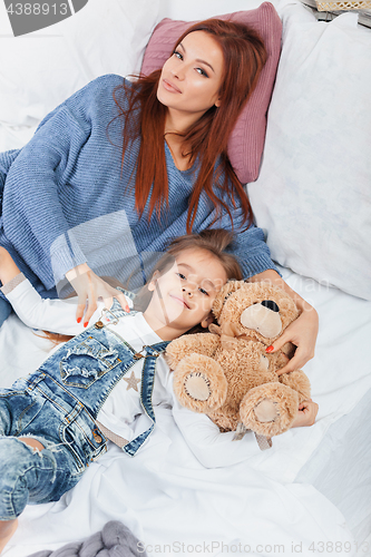 Image of A little cute girl enjoying, playing and creating with toy with mother