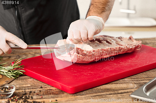 Image of Man cooking meat steak on kitchen