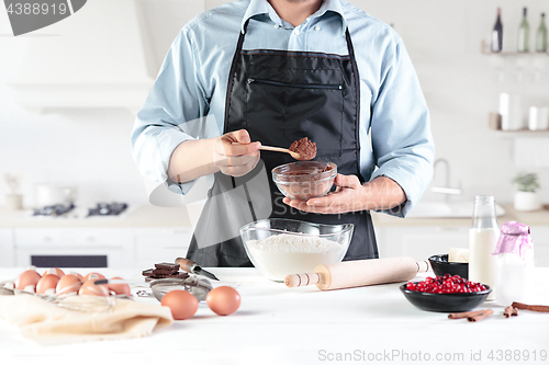 Image of A cook with eggs on a rustic kitchen against the background of men\'s hands