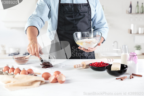 Image of A cook with eggs on a rustic kitchen against the background of men\'s hands