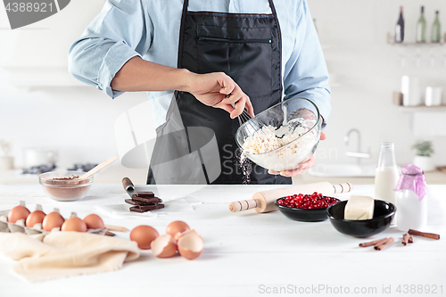 Image of A cook with eggs on a rustic kitchen against the background of men\'s hands