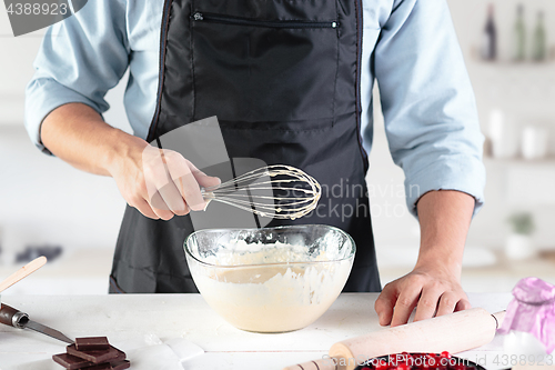 Image of A cook with eggs on a rustic kitchen against the background of men\'s hands