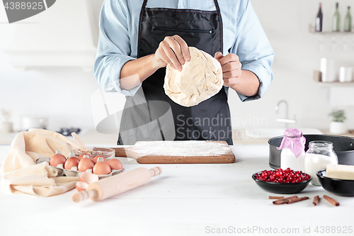 Image of A cook with eggs on a rustic kitchen against the background of men\'s hands