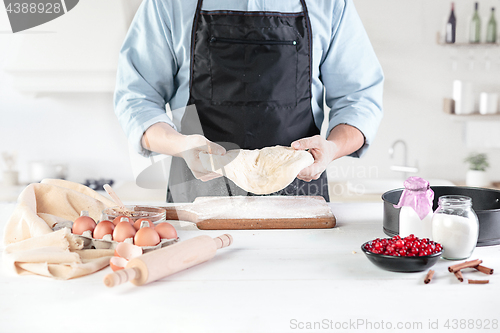 Image of A cook with eggs on a rustic kitchen against the background of men\'s hands