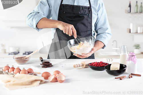 Image of A cook with eggs on a rustic kitchen against the background of men\'s hands