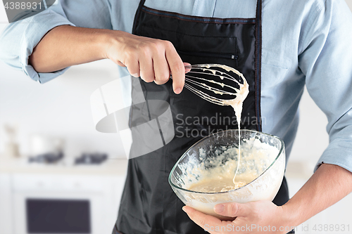 Image of A cook with eggs on a rustic kitchen against the background of men\'s hands