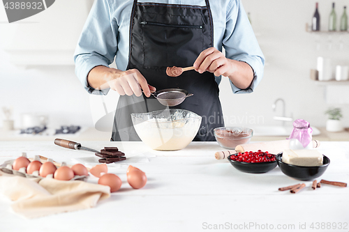 Image of A cook with eggs on a rustic kitchen against the background of men\'s hands