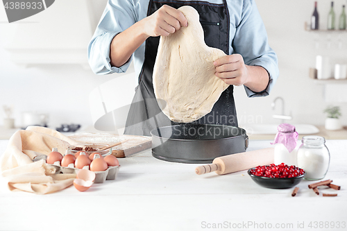 Image of A cook with eggs on a rustic kitchen against the background of men\'s hands