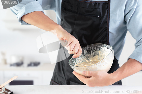 Image of A cook with eggs on a rustic kitchen against the background of men\'s hands