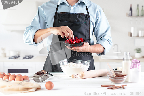 Image of A cook with eggs on a rustic kitchen against the background of men\'s hands