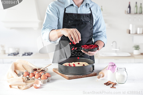 Image of A cook with eggs on a rustic kitchen against the background of men\'s hands