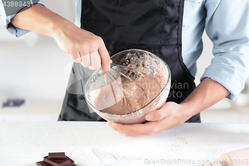 Image of A cook with eggs on a rustic kitchen against the background of men\'s hands