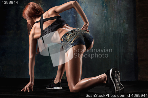 Image of Muscular young woman athlete on black