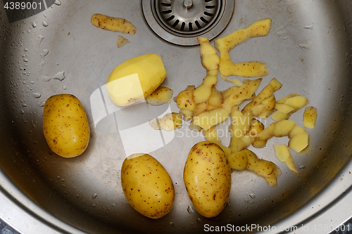 Image of potatoes and potato peelings in the sink