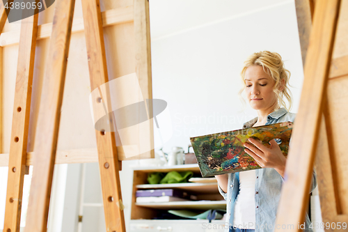 Image of woman with easel painting at art school studio