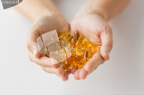 Image of hands holding cod liver oil capsules