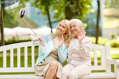 Image of daughter and senior mother taking selfie at park