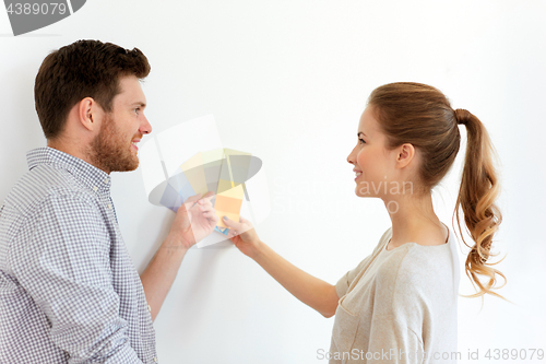 Image of happy couple with color samples at new home