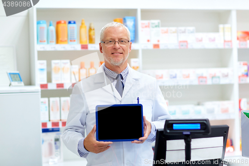 Image of senior apothecary at pharmacy cash register