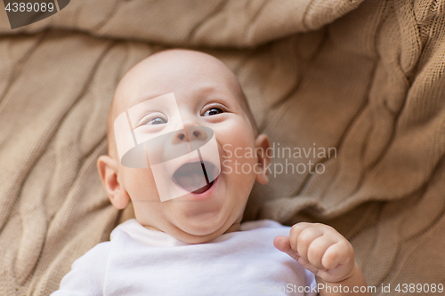 Image of sweet little baby boy lying on knitted blanket