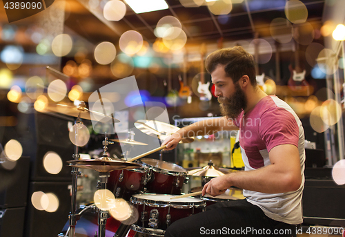 Image of male musician playing cymbals at music store