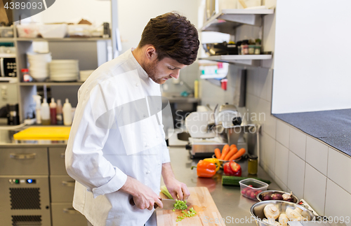 Image of happy male chef cooking food at restaurant kitchen